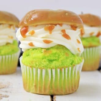 Caramel apple cupcakes in a row on a white wooden surface
