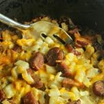 Prepared slow cooker breakfast casserole with a large metal spoon scooping out a serving