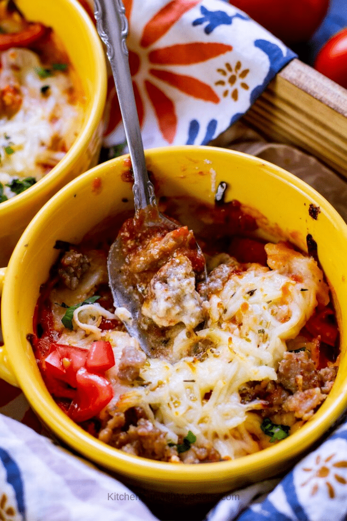 Up close picture of a baked lasagna casserole with a spoon in the bowl