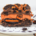 Up close picture of a slice of halloween brownies with oreos on a white and black plate