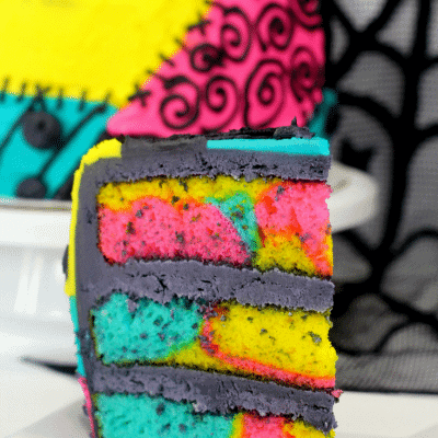 Up close picture of a slice of patchwork sally cake on a white plate