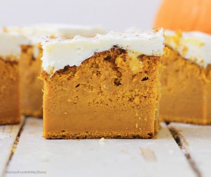 Up close picture of a sliced pumpkin bar topped with cream cheese frosting