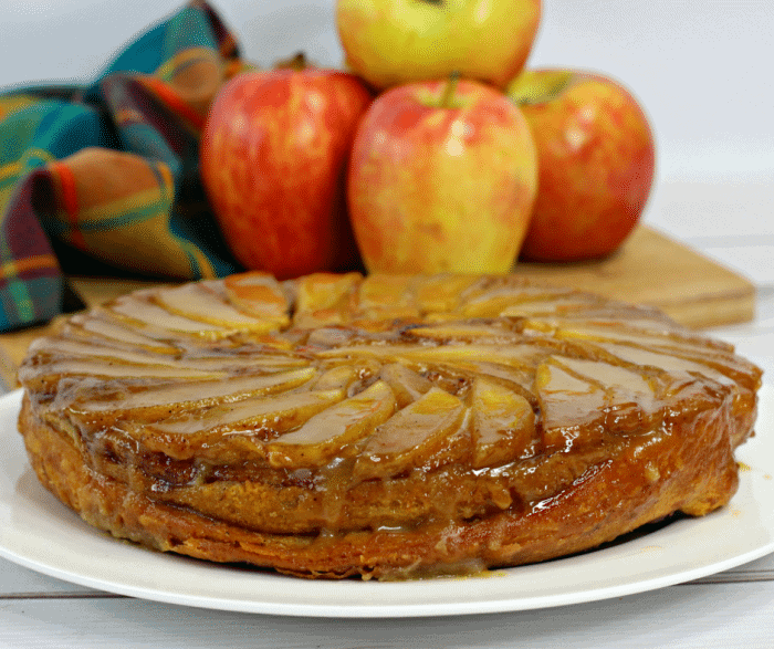 Up close picture of an apple upside down cake on a white plate