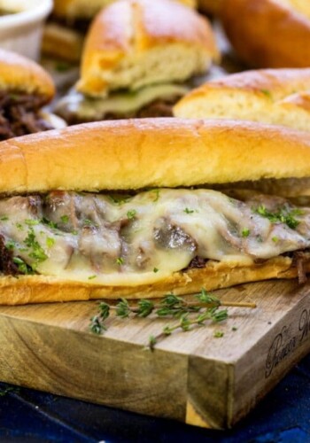 Up close picture of french dip sandwiches on a cutting board ready to serve