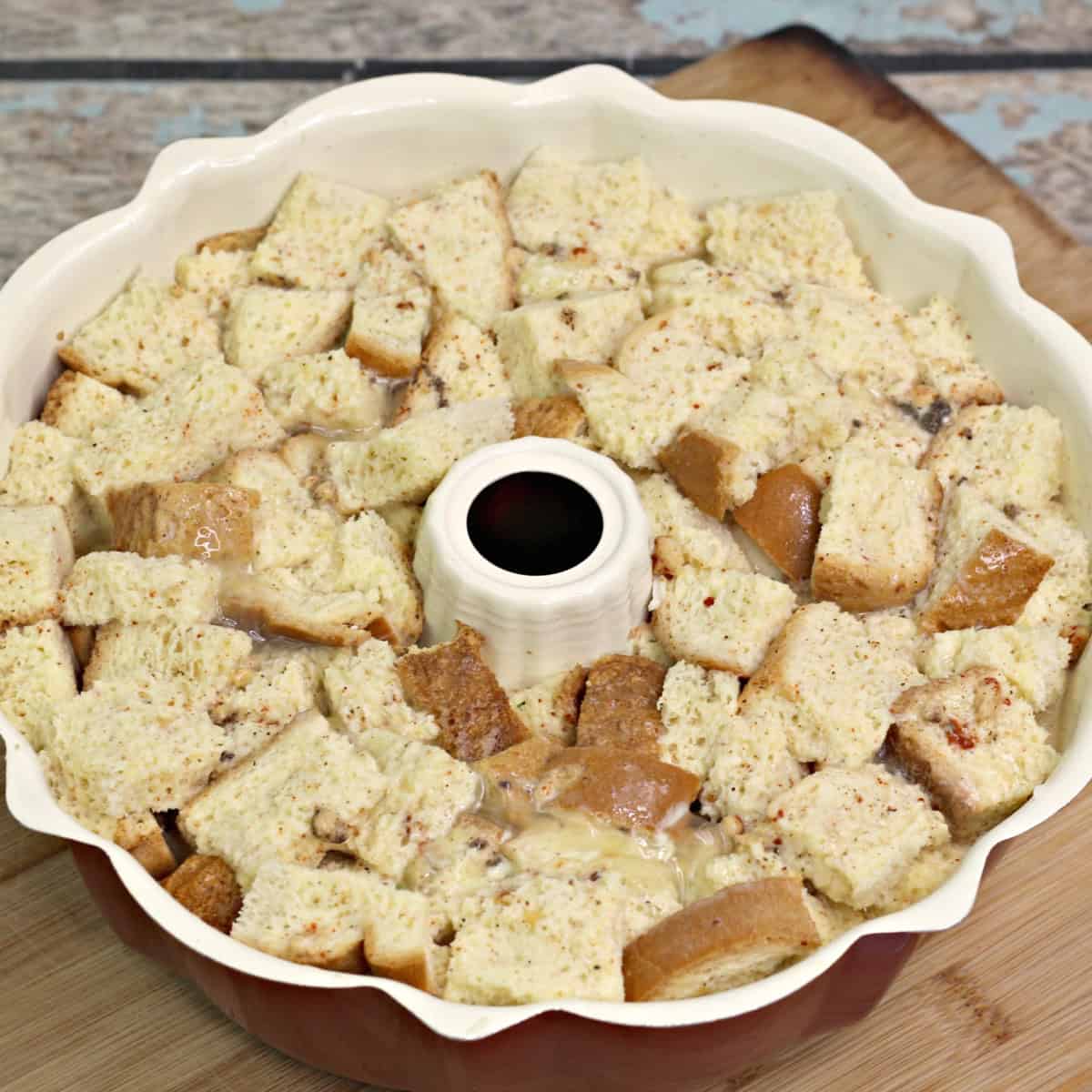 cubed bread soaked in an egg mixture in a bundt pan