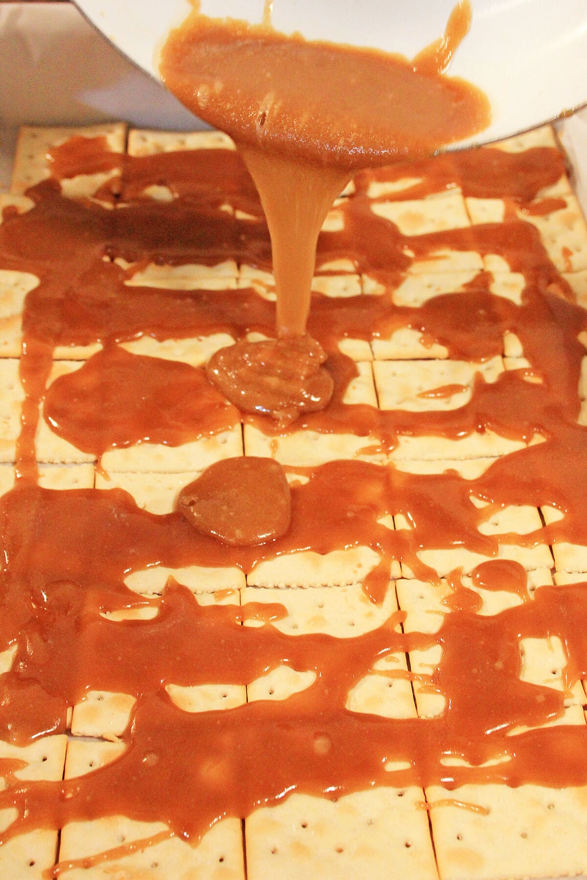 Covering saltine crackers with caramel mixture