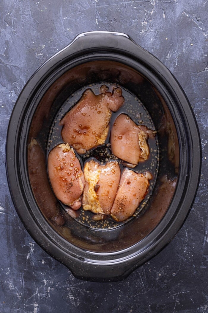 sauce over chicken thighs in a slow cooker
