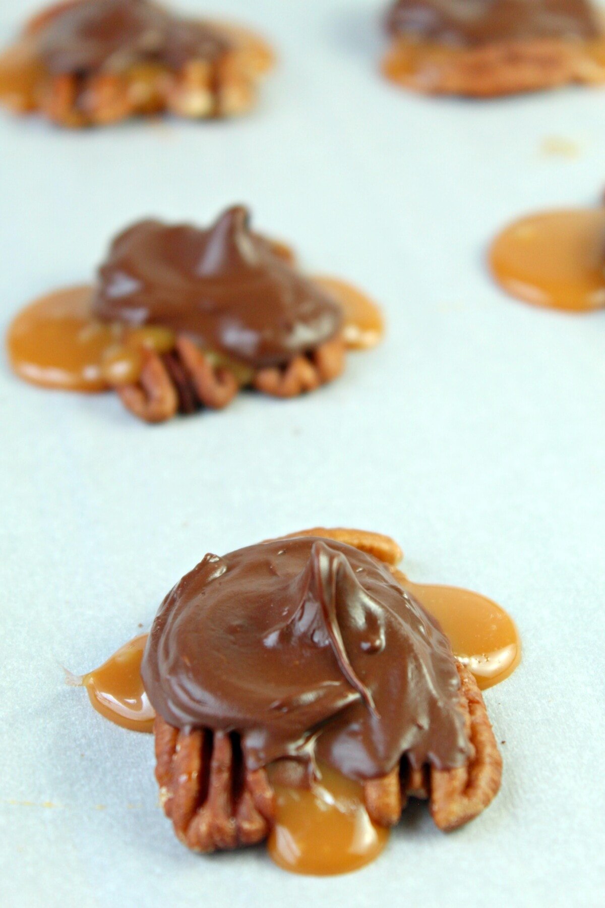 Chocolate Turtle Clusters on wax paper
