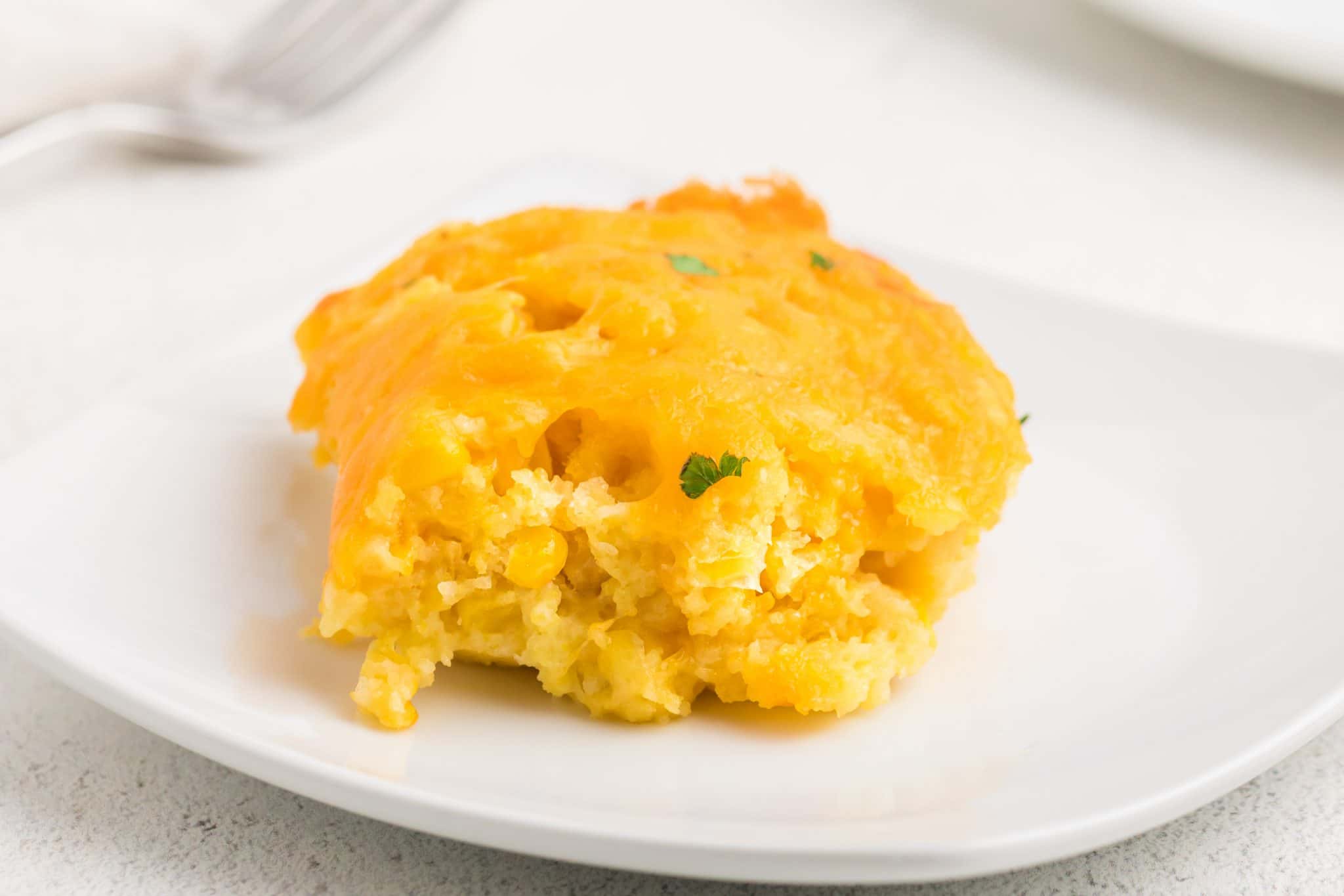 A serving of corn casserole on a white plate