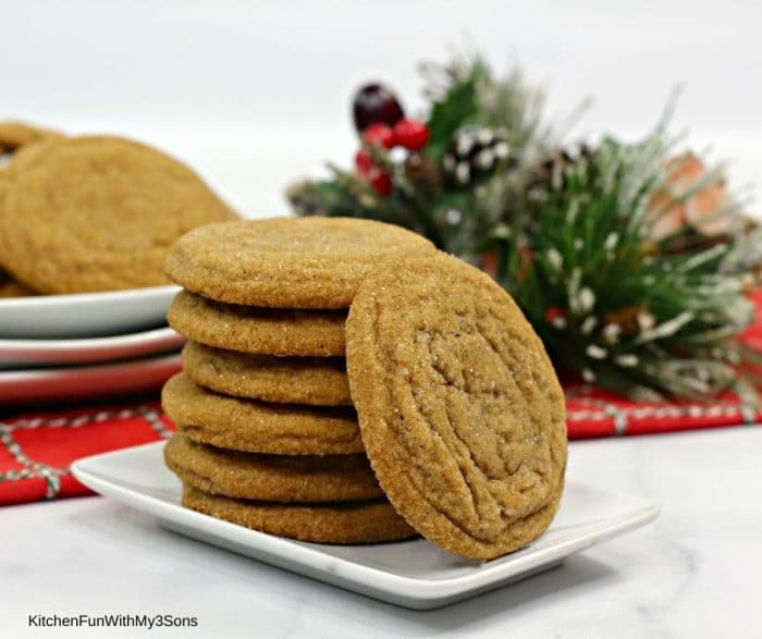 Soft Molasses cookies stacked on a plate in front of holiday decorations