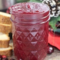 Instant Pot Cranberry Butter in a mason jar next to holiday decorations
