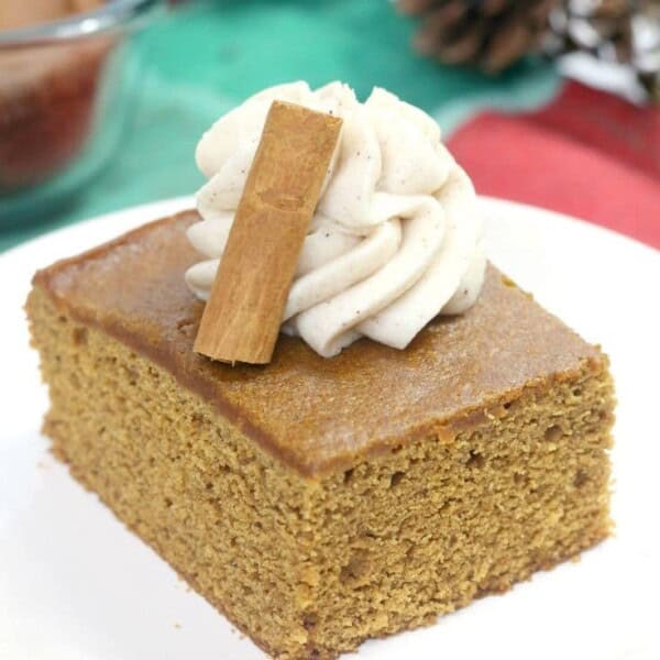 Old fashioned gingerbread cake on a white plate with cinnamon frosting