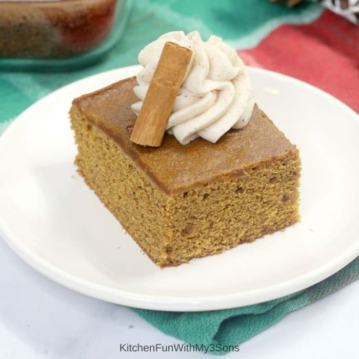 Single slice of old fashioned gingerbread cake on a white plate with frosting