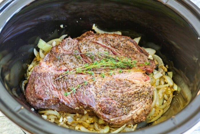 Chuck roast in a slow cooker with onions