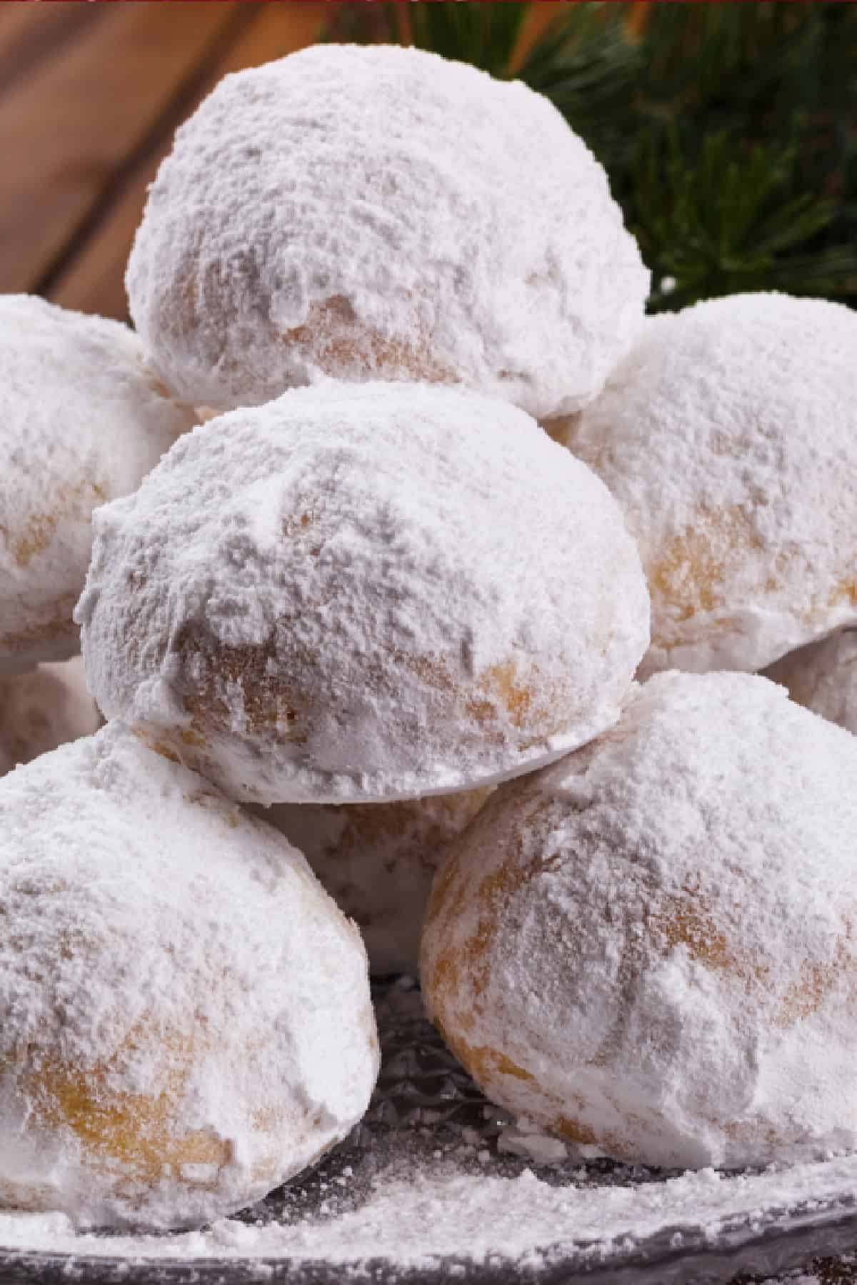 With their melt-in-your-mouth texture and sweet, buttery flavor, these Snowball Cookies are a holiday classic. Just 6 ingredients! Close up of a pile of snowball cookies on a plate