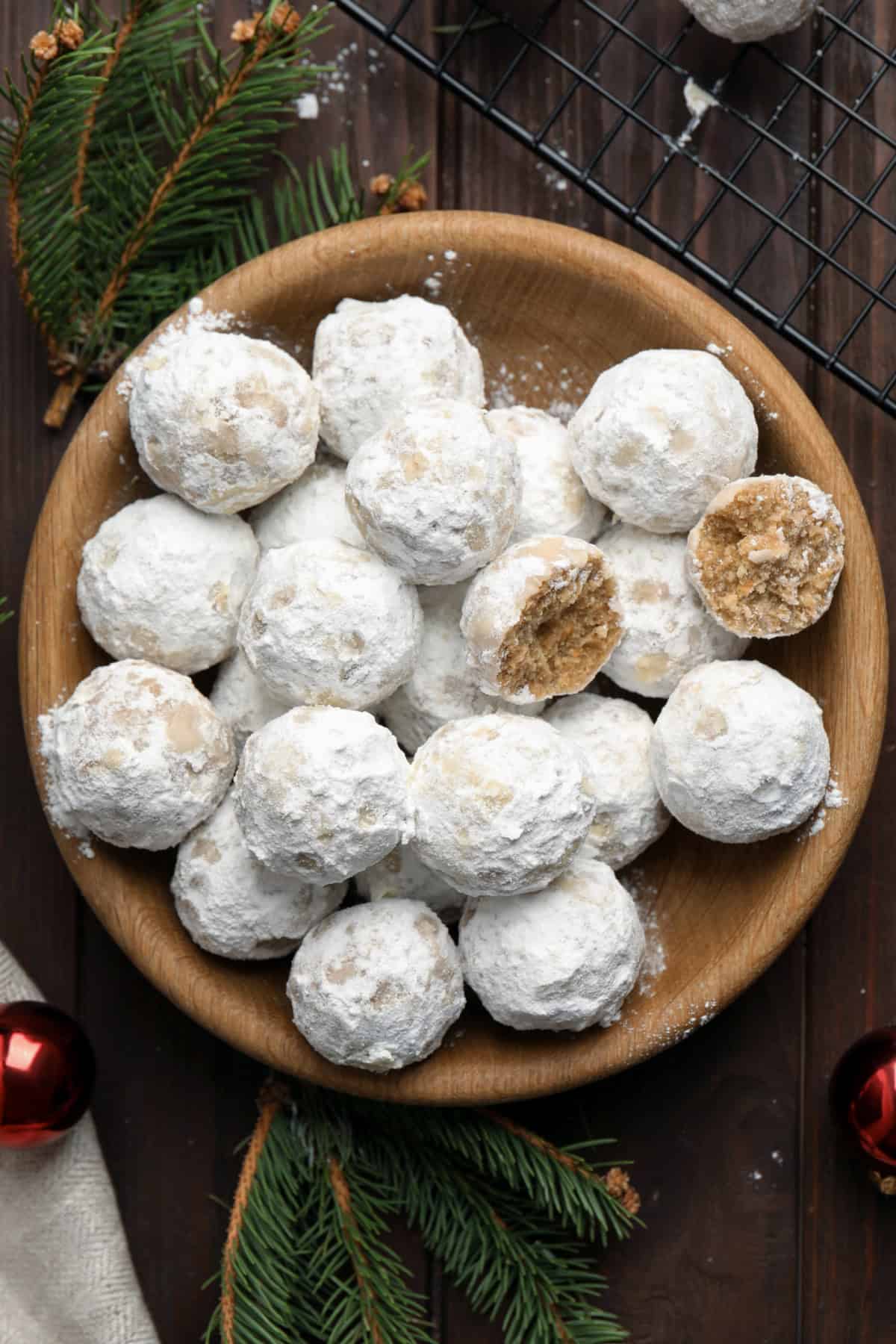 Overhead view of a bowl of snowball cookies, one cut in half