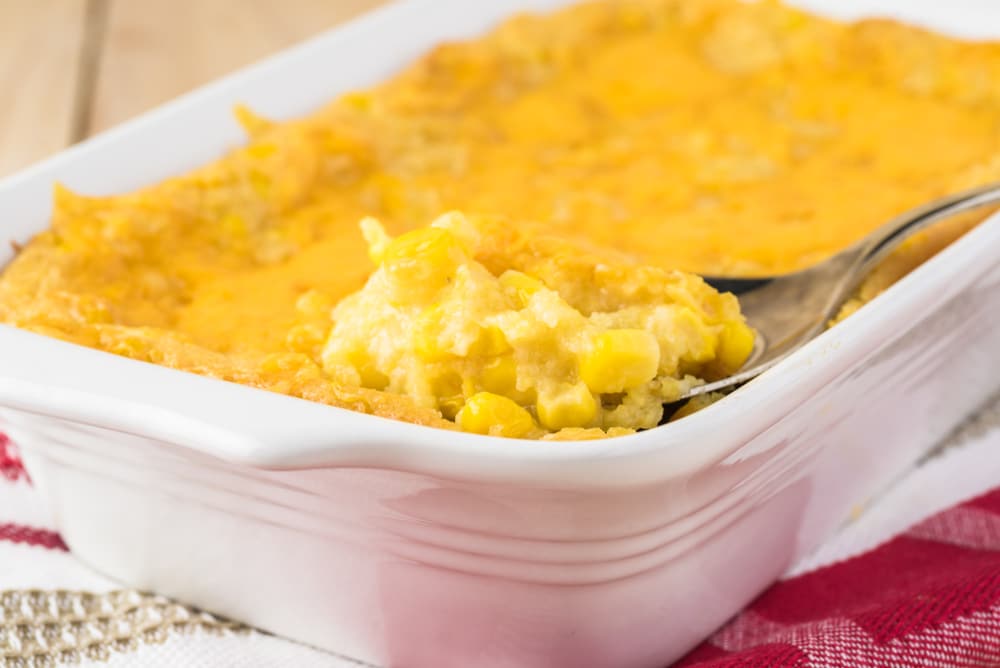 A spoon scooping out a serving of corn casserole