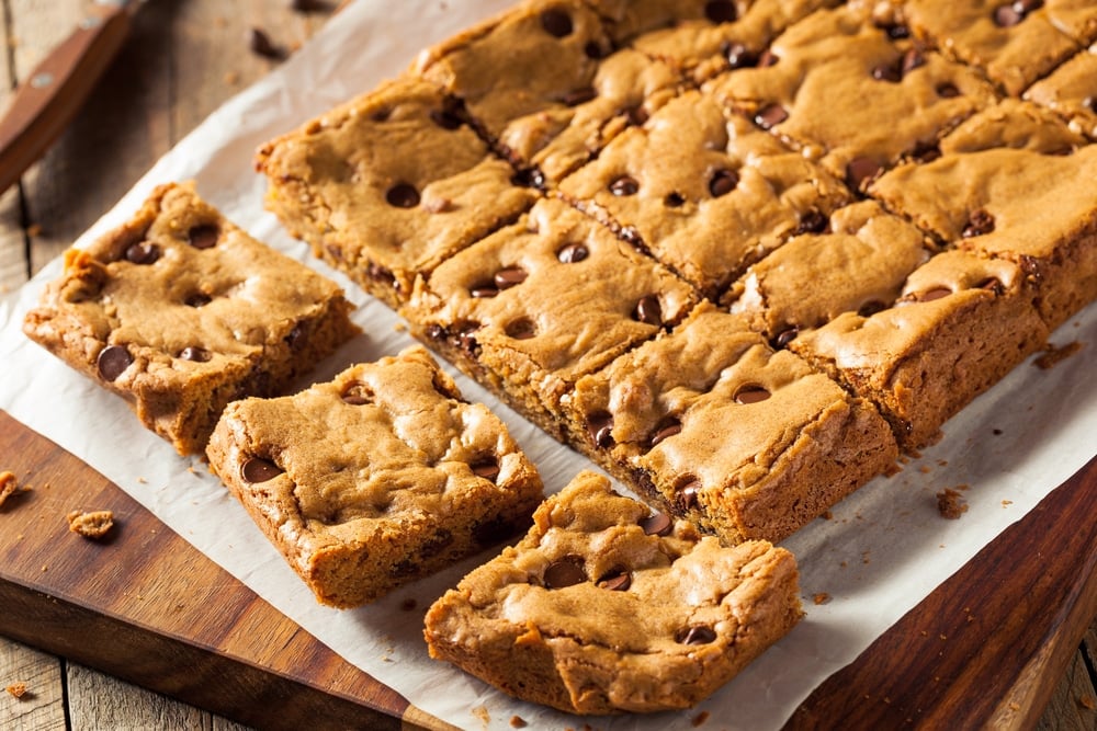 Angled view of chocolate chip cookie bars on parchment paper, sliced