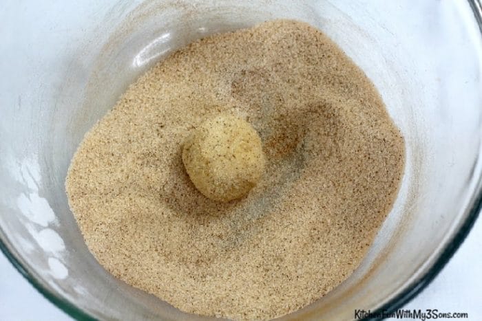 Rolling cookie dough in cinnamon sugar
