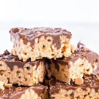 Stack of chocolate caramel oat cereal bars on a white platter