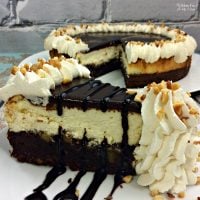 Brownie Sundae Cheesecake is a yummy dessert mashup with a layer of brownie and a layer of cheesecake. Top it off with chocolate ganache and homemade whipped cream.