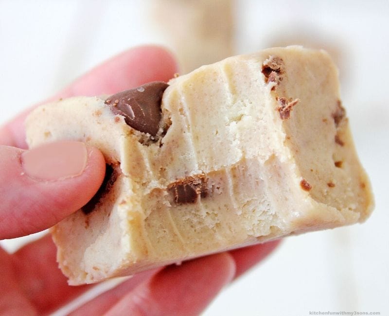 chocolate chip cookie dough fudge in a hand with a bite out of it