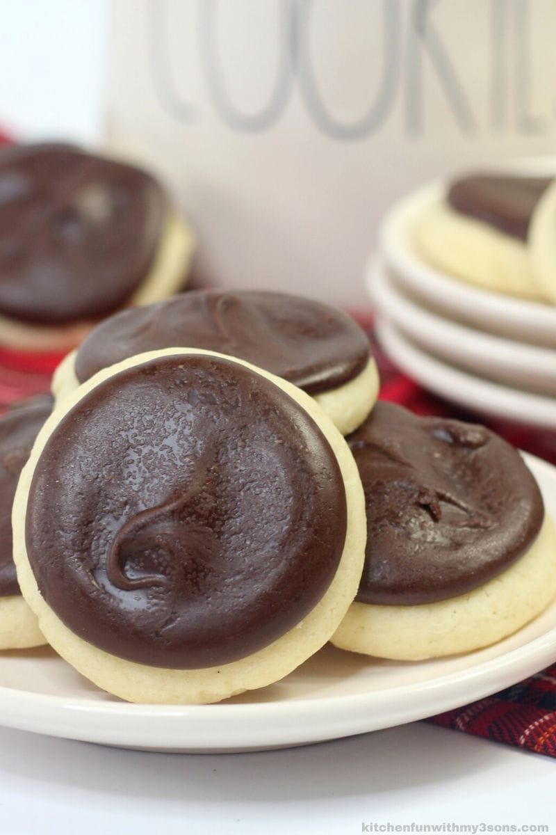 A small pile of cookies with chocolate frosting on a plate.