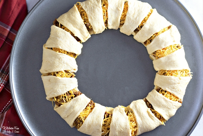 Unbaked taco ring made with crescent rolls folded around ground beef filling.