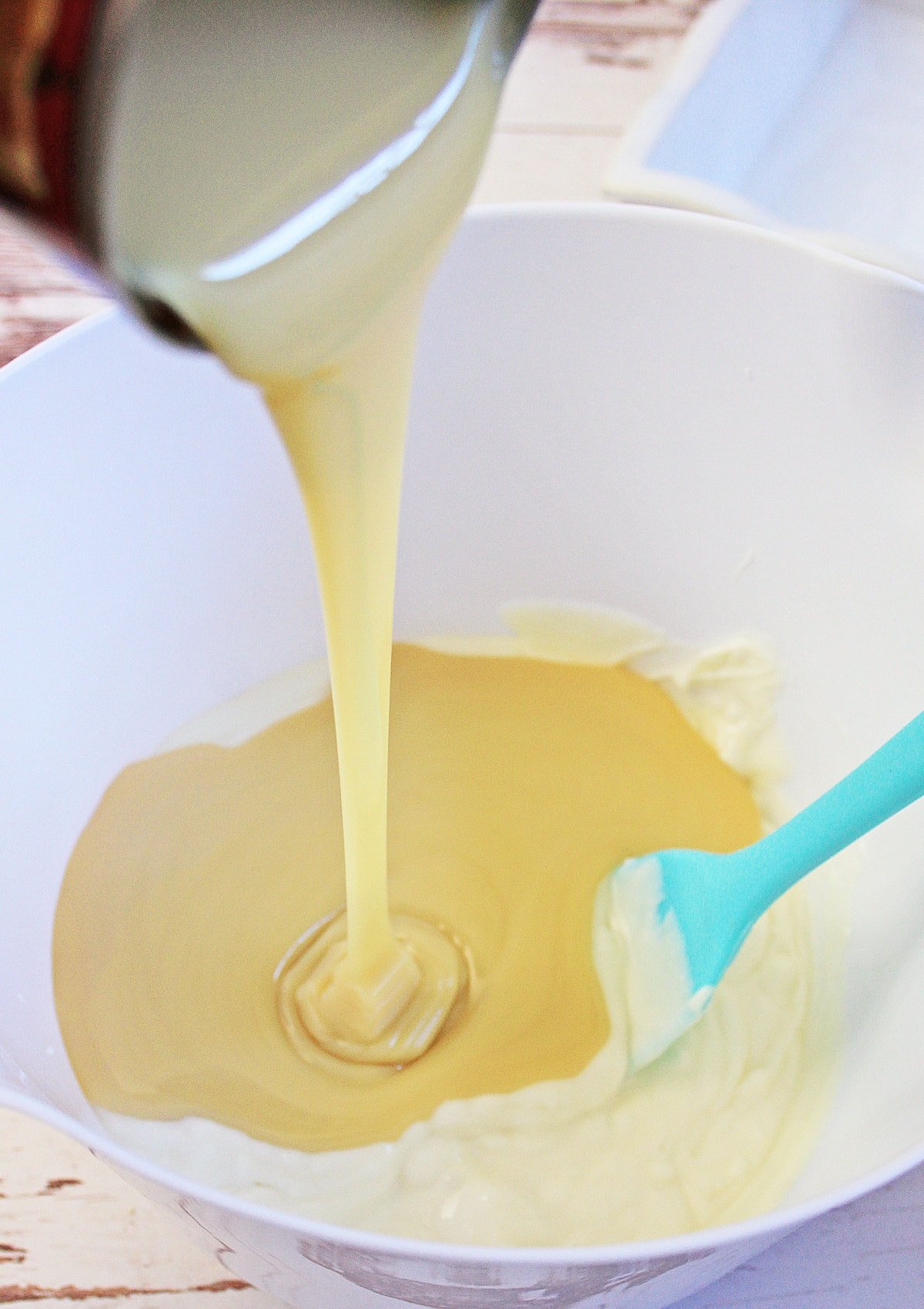 pouring sweetened condensed milk into the fudge