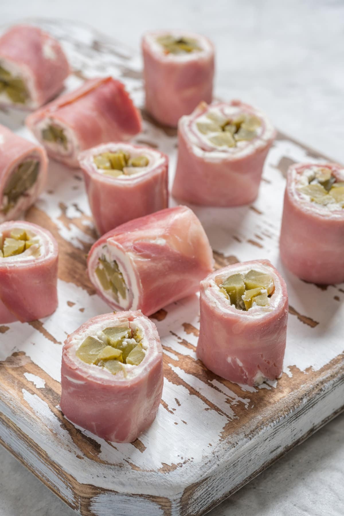 Ham and Pickle Roll ups on a cutting board