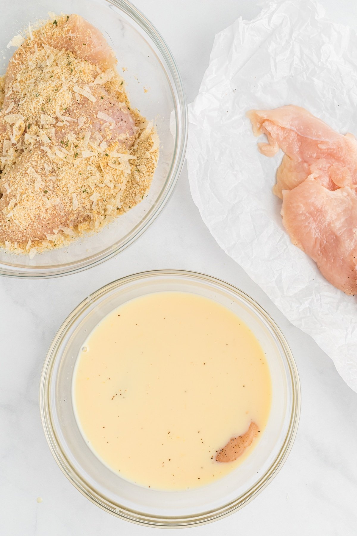 Chicken breasts dipped in an egg wash and bread crumbs