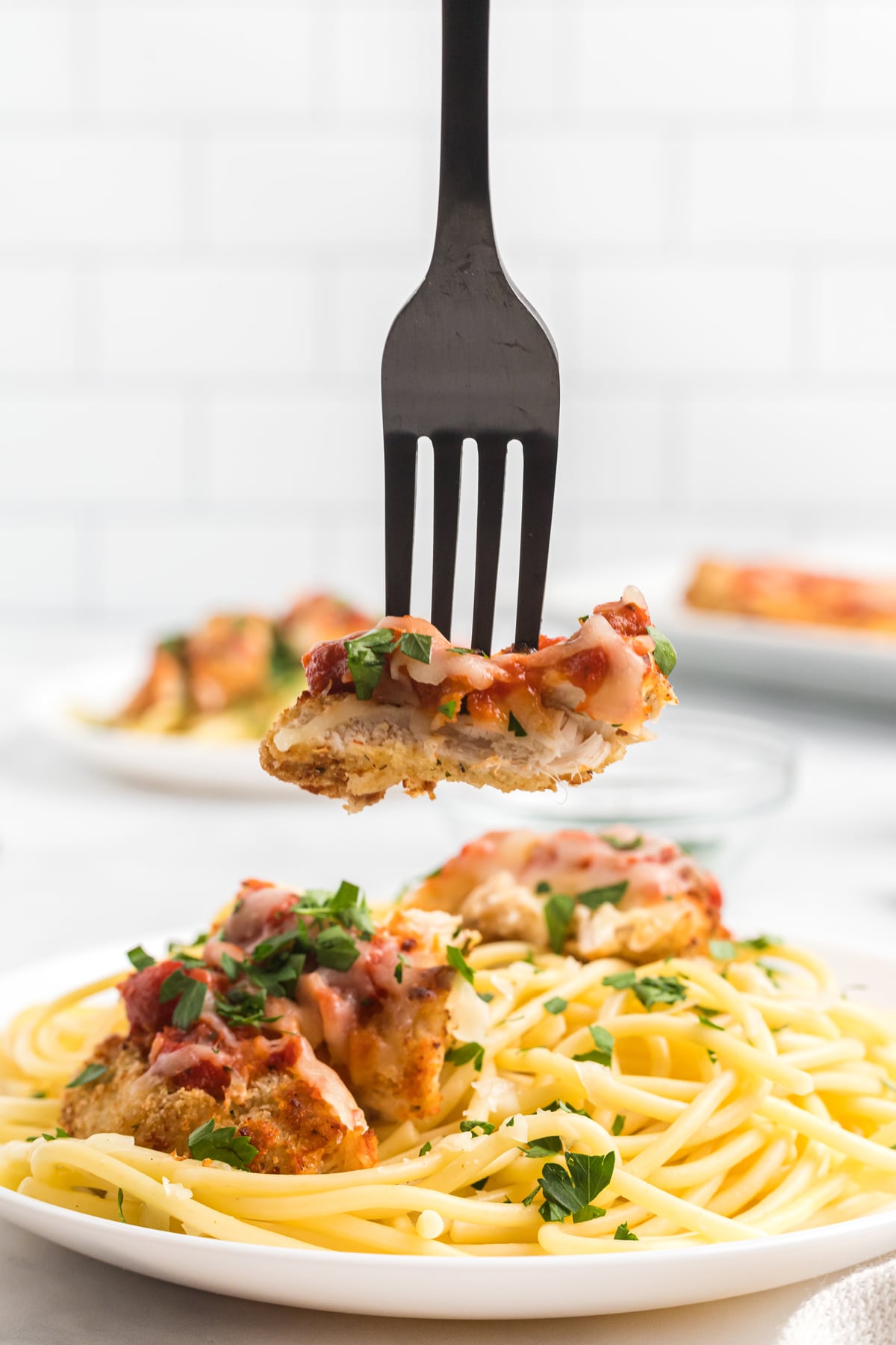 A bite of chicken parmesan on a fork 