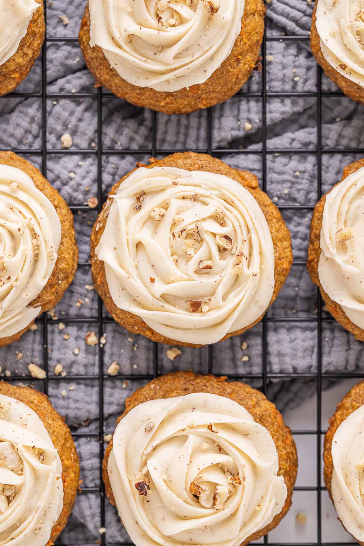 Overhead view of carrot cake cookies with brown butter cream cheese frosting on a wire rack