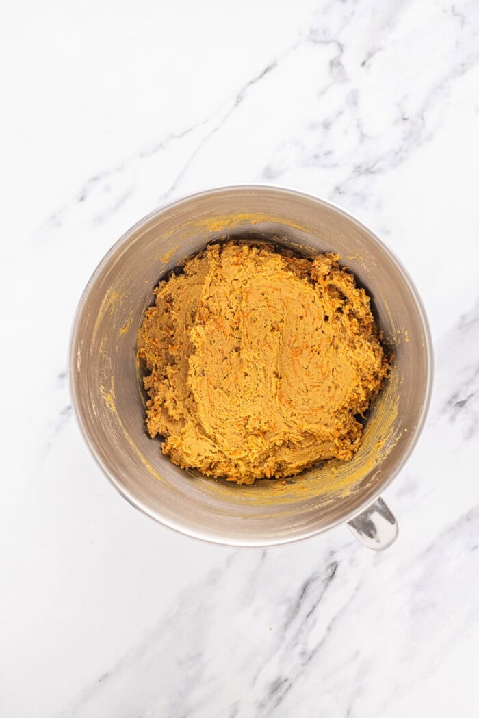 Carrot cake cookie dough in a metal bowl
