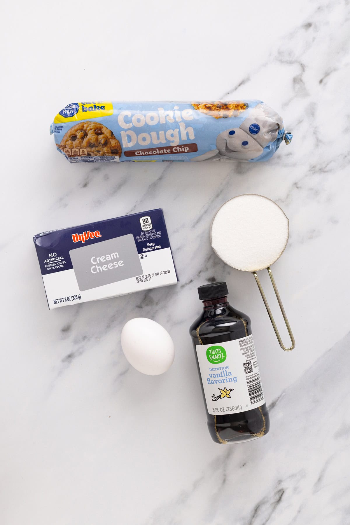 Creamy, tangy cheesecake filling is stuffed between layers of cookie dough in these Chocolate Chip Cheesecake Bars. Overhead view of ingredients needed to make chocolate chip cheesecake bars