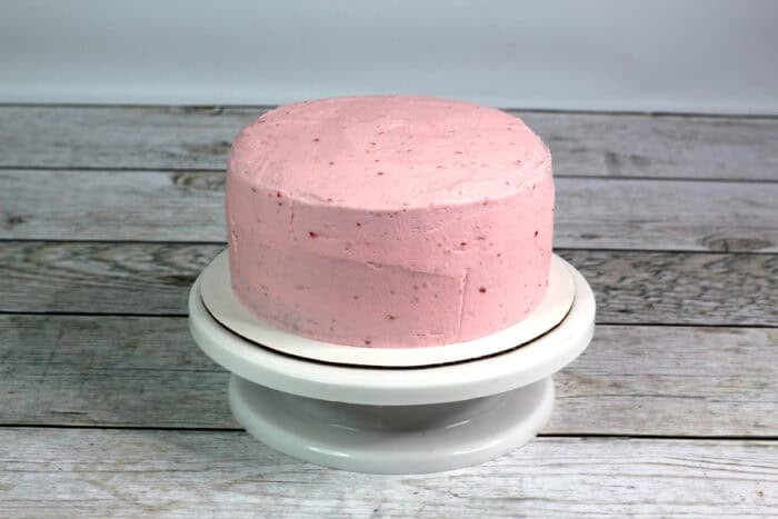 Chocolate layer cakes coated with strawberry frosting
