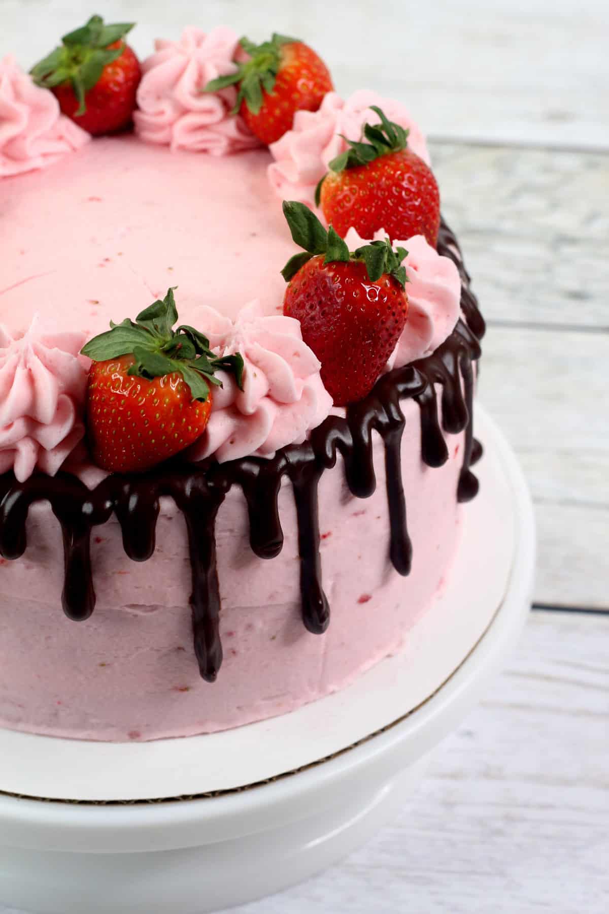 Close up of the side of a chocolate strawberry cake with chocolate ganache and fresh strawberries