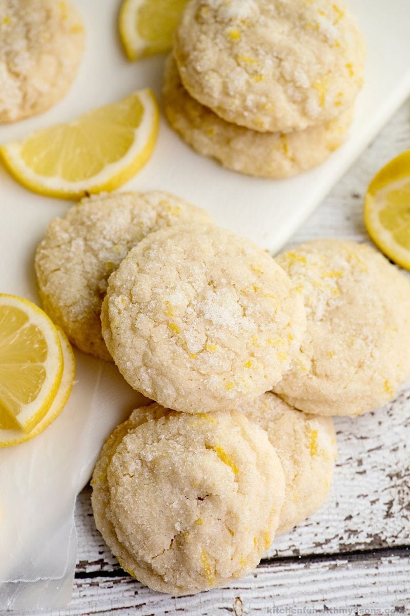 Overhead view of lemon cookies on a cutting board and counter