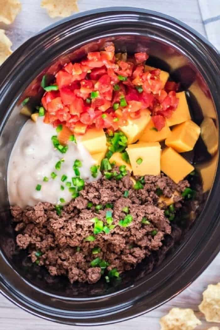 Velveeta cheese, Rotel, and ground beef come together in this cheesy and flavorful Hamburger Dip. Made in the slow cooker! Rotel, Velveeta, ground burger, and cream of mushroom soup in a crockpot