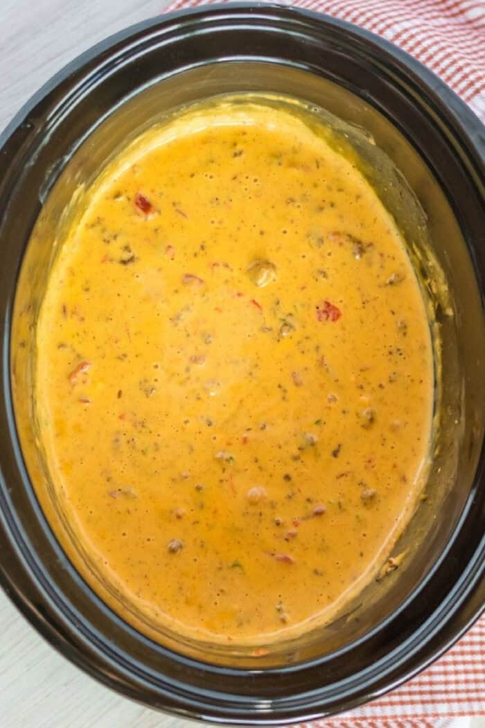 Velveeta cheese, Rotel, and ground beef come together in this cheesy and flavorful Hamburger Dip. Made in the slow cooker! Overhead view of slow cooker cheesy hamburger dip