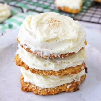 Three stacked carrot cake cookies with cream cheese frosting.