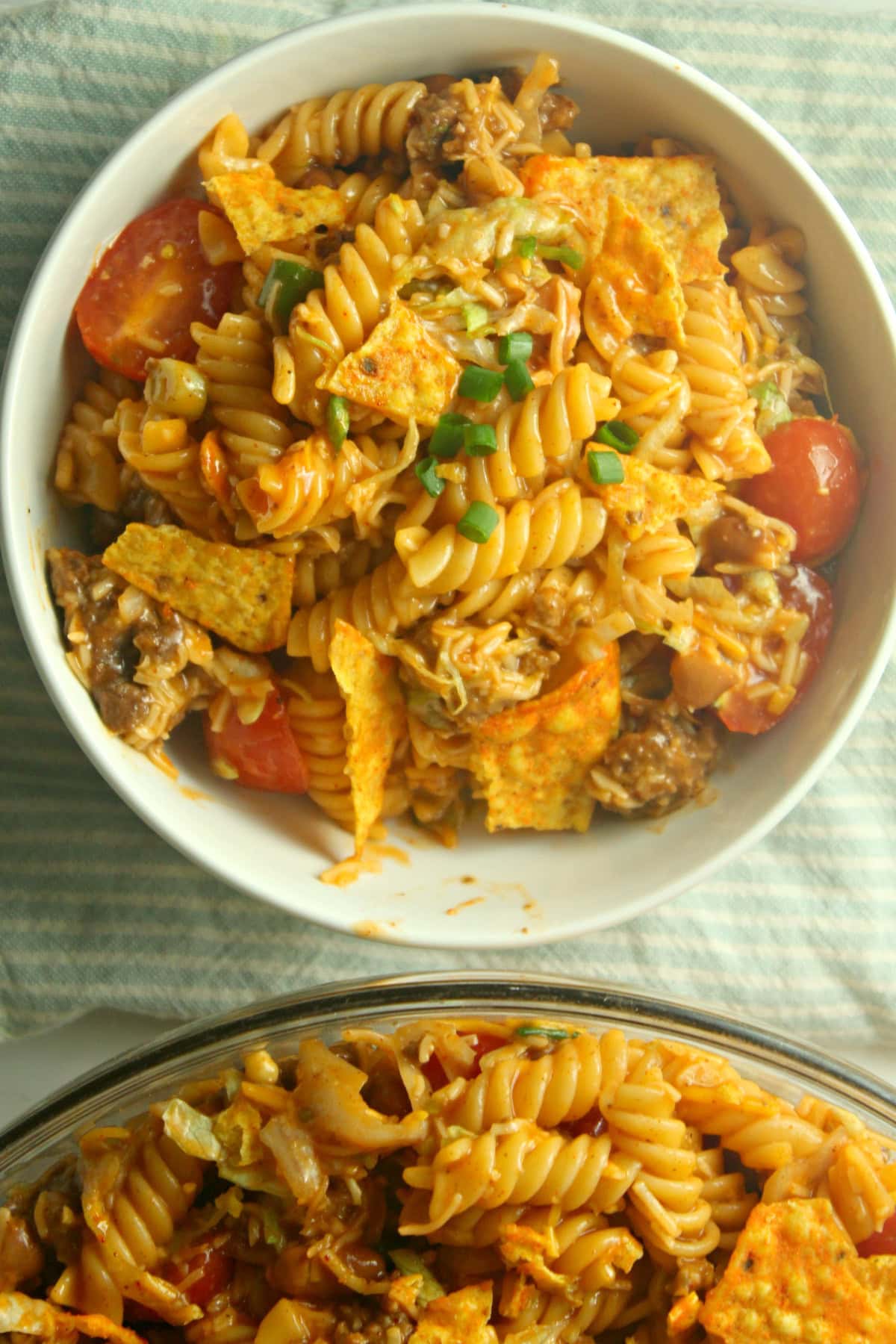 A fun twist on a classic, Taco Pasta Salad is made with rotini, ground beef, and your favorite taco toppings tossed with French dressing. Dorito Taco Pasta Salad bowl