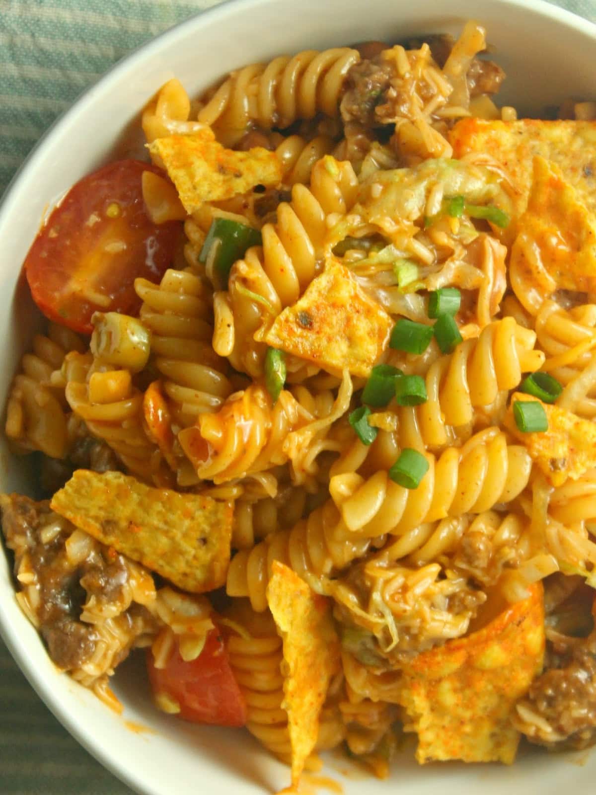 A fun twist on a classic, Taco Pasta Salad is made with rotini, ground beef, and your favorite taco toppings tossed with French dressing. Dorito Taco Pasta Salad in a bowl