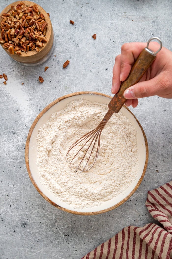 Tender, moist vanilla cake is dotted with coconut and pecans, then topped with cream cheese frosting in this Italian Cream Cake recipe. Whisking dry ingredients together