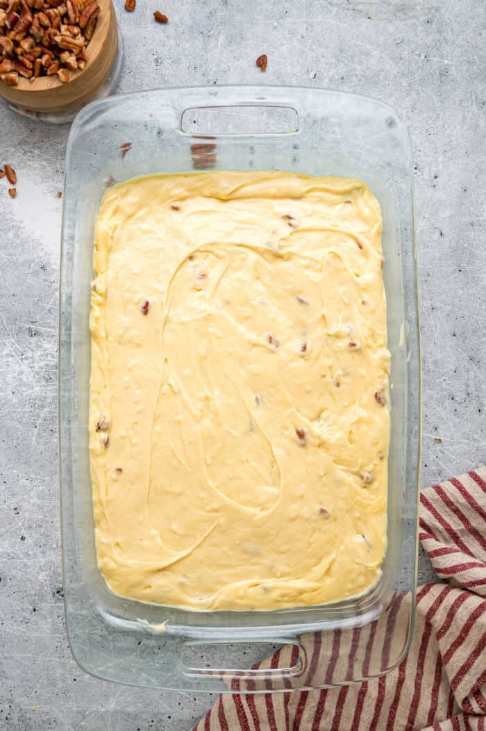 Tender, moist vanilla cake is dotted with coconut and pecans, then topped with cream cheese frosting in this Italian Cream Cake recipe. Italian cream cake batter in a cake pan