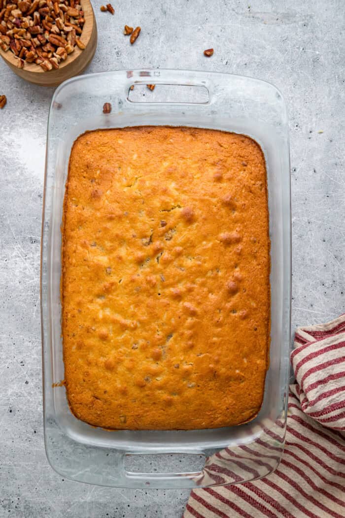 Tender, moist vanilla cake is dotted with coconut and pecans, then topped with cream cheese frosting in this Italian Cream Cake recipe. Unfrosted Italian cream cake in a baking dish