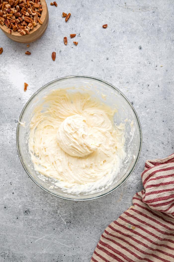 Tender, moist vanilla cake is dotted with coconut and pecans, then topped with cream cheese frosting in this Italian Cream Cake recipe. A bowl of cream cheese frosting