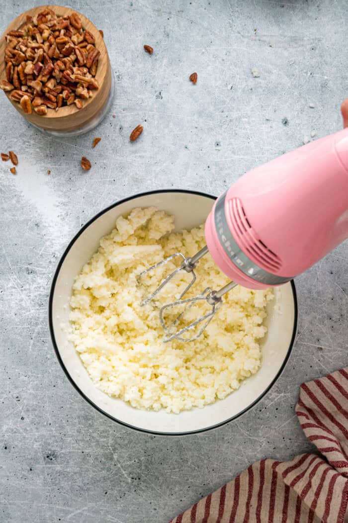 Tender, moist vanilla cake is dotted with coconut and pecans, then topped with cream cheese frosting in this Italian Cream Cake recipe. Creaming butter and sugar in a bowl