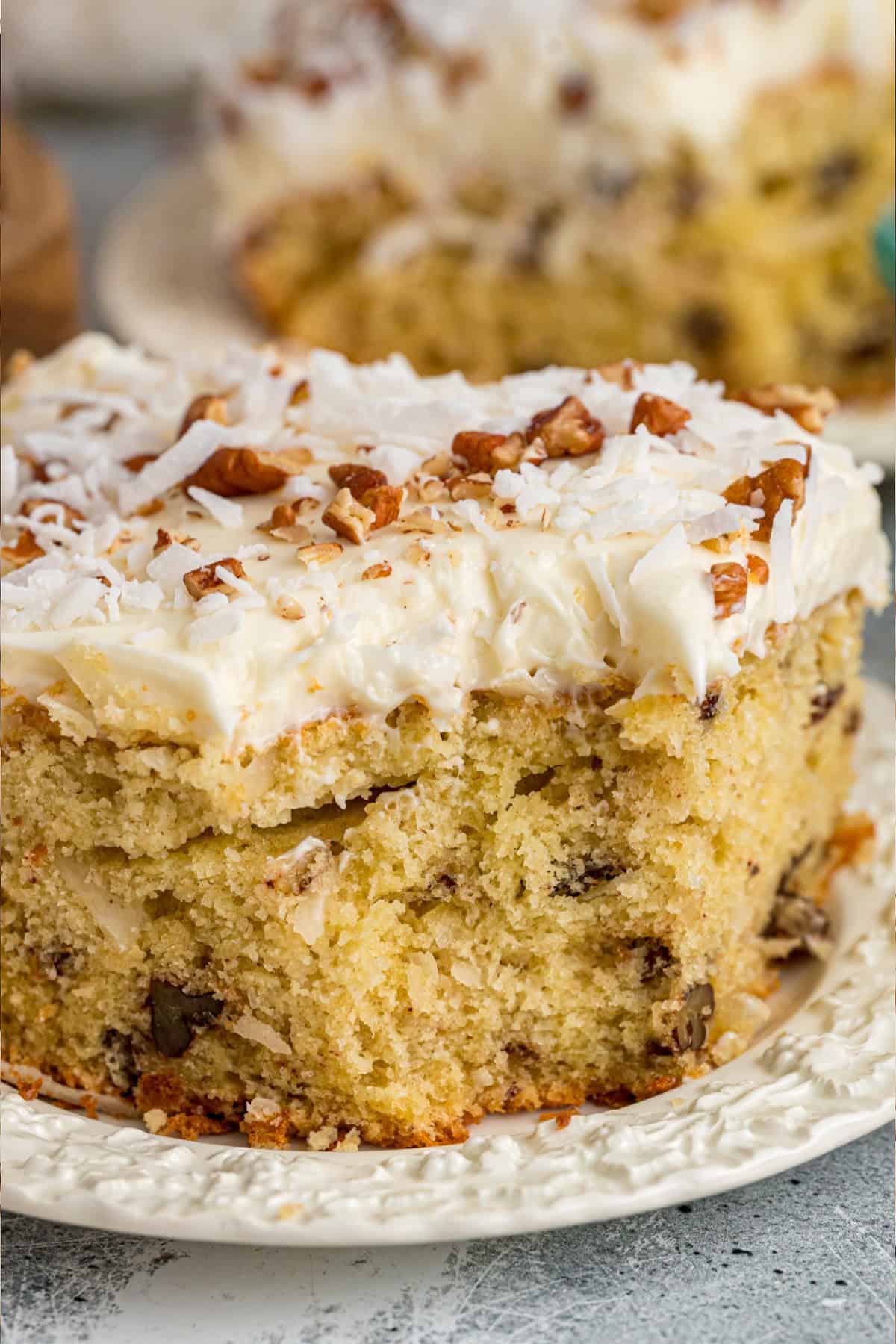 Tender, moist vanilla cake is dotted with coconut and pecans, then topped with cream cheese frosting in this Italian Cream Cake recipe. Italian Cream Cake slice with a bite taken out