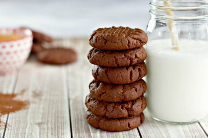 Chocolate Peanut Butter Cookies stacked next to a jar of milk
